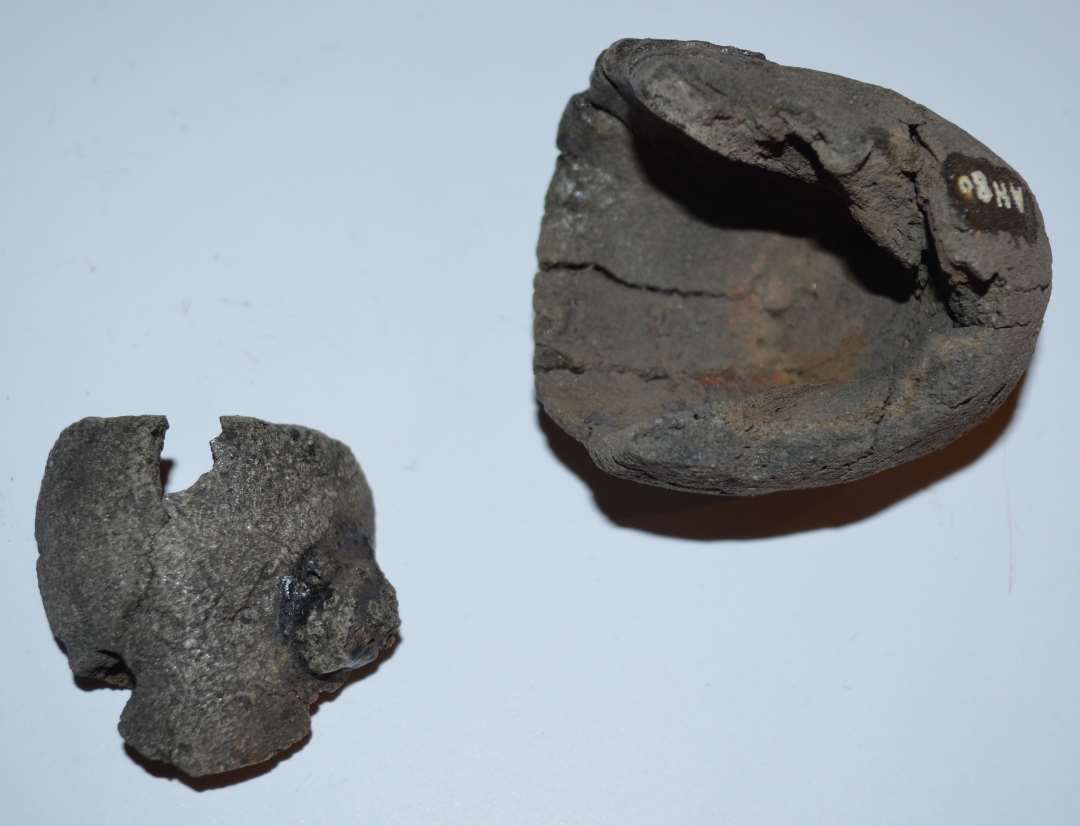 Dele til en digel og rester af yderlig en eller flere�den ene m�ler:�h�j 4,5 cm�diam. 3,5 cm�fastsmeltet slagge og rest af v�vning